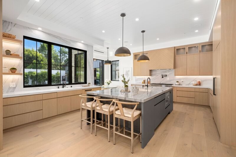 Cocina integral con acabados de lujo e isla en medio con lamparas colgantes