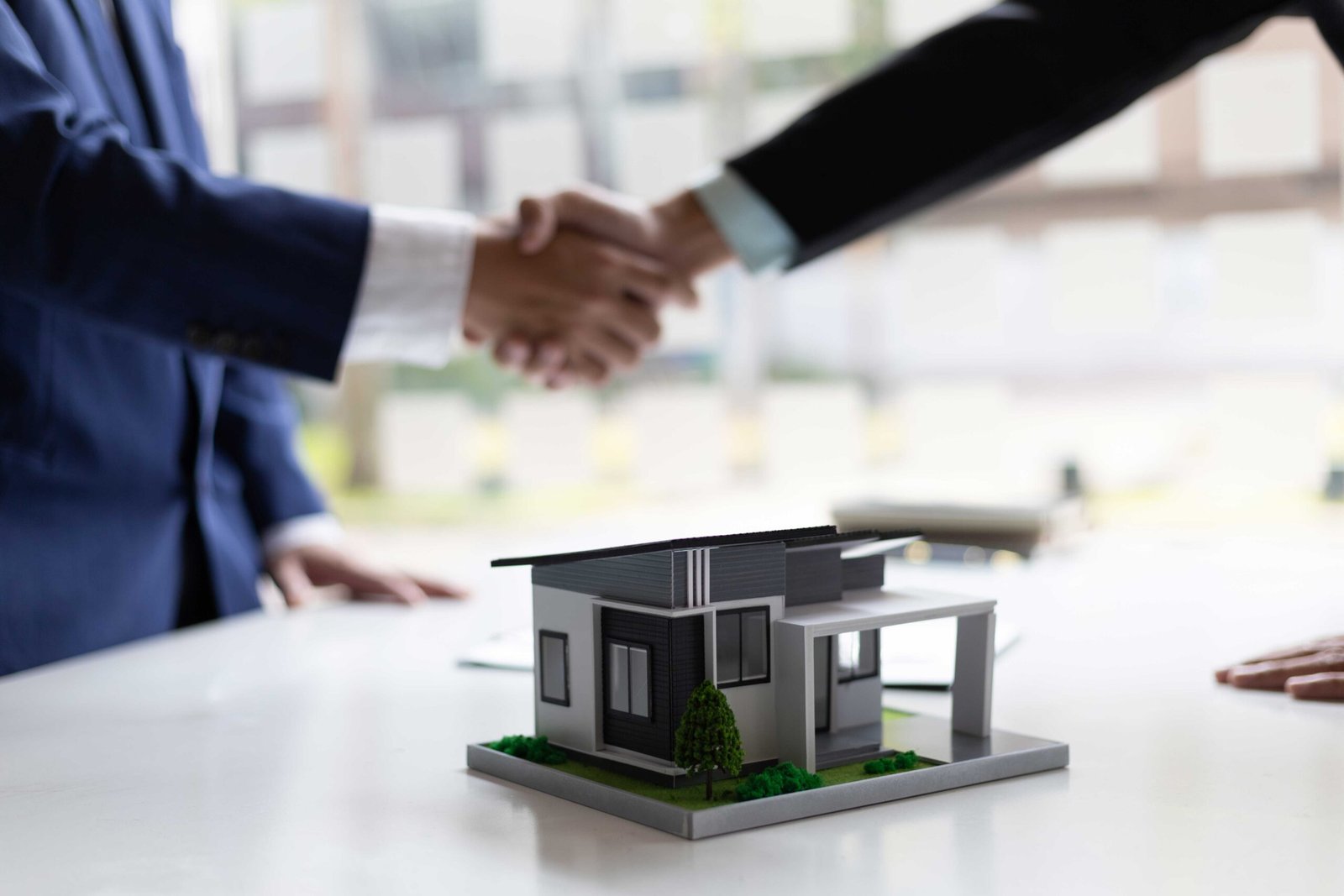 Dos personas haciendo un trato de compraventa de una casa
